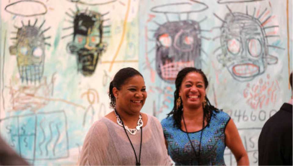 Lisane Basquiat and Jeanine Basquiat stand in front of Jean-Michel Basquiat modern art 